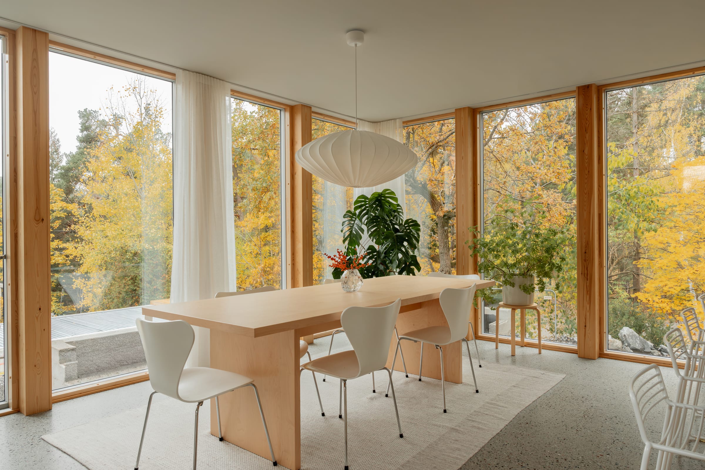 Matplats vid fönster i hörnet, med utsikt mot höstträd
